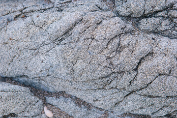 texture of gray cracked stone with beach sand. Wallpaper for phone, computer with stone mountain...