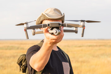 a tourist guy launches a quadcopter and holds it in his hand