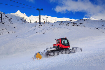 A snow groomer (tracked vehicle with a dozer blade) at work on a ski field. Photographed at Whakapapa ski area, Mount Ruapehu, New Zealand