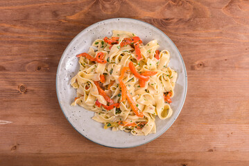 Fettuccine pasta with creamy bell pepper sauce. Serving of italian vegan pasta on a plate, close-up, overzu view