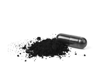 Charcoal capsules and powder isolated on white.