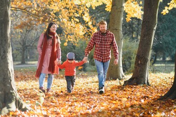 happy young family spending time outdoor in the autumn park