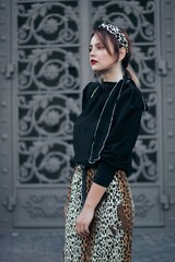 elegant woman on the background of large door shutters. Street style.