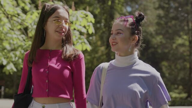 The girls will miss lessons in the park. Two girls are walking in the park.