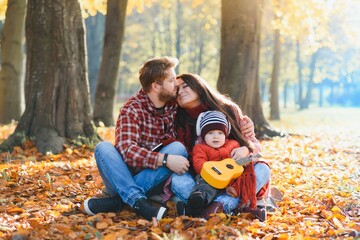 happy young family spending time outdoor in the autumn park