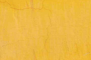 yellow painted plaster wall with cracks as harmonic background