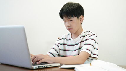 책상에서 노트북을 사용하고 있는 소년 a boy using laptop on the desk