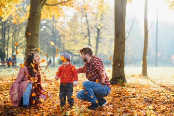 happy family mother father and baby on autumn walk in the park