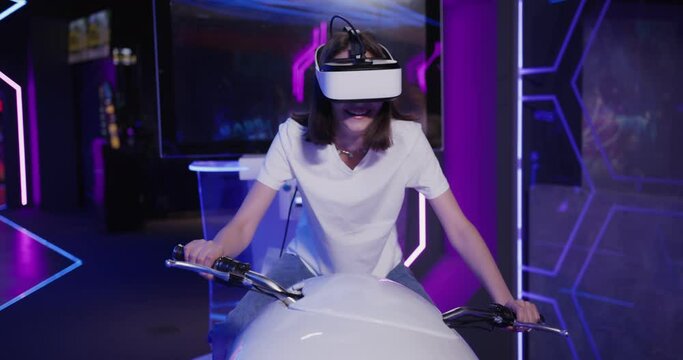European woman in virtual reality glasses controls a motorcycle