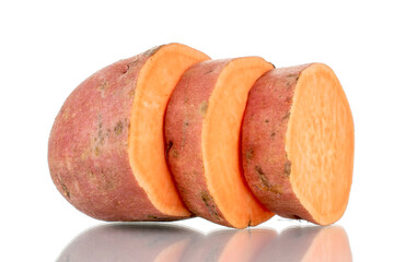 One whole fresh juicy sweet potato cut into several slices, close-up, isolated on white.
