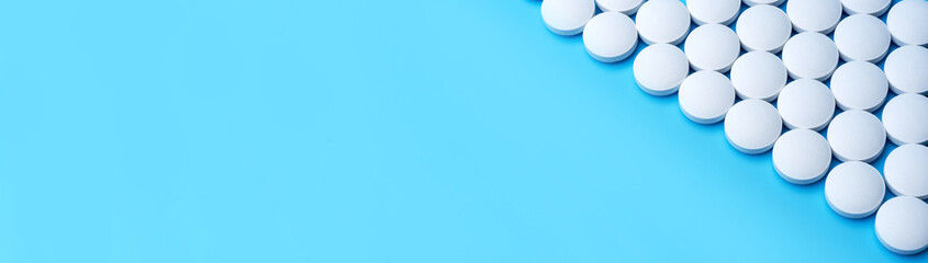 White medical pills on a blue background in the upper right corner.