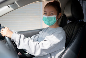Fototapeta na wymiar Beautiful young girl in a mask sitting in a car, car insurance