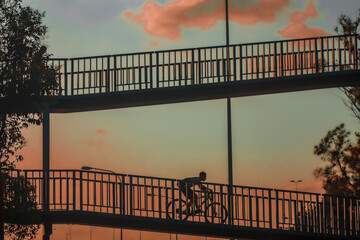 Fototapeta na wymiar Bike man silhouette on a bridge 3.