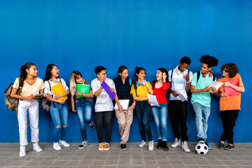 Obraz premium Group of happy multiracial teenage high school students talking and laughing before class. Back to school. Copy space