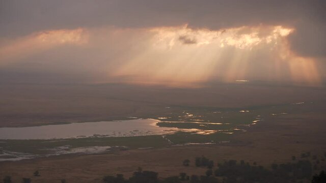 Ngorongoro Crater. Incredible view in the golden hour with sun rays entering between the clouds. Tanzania, Africa 4K.