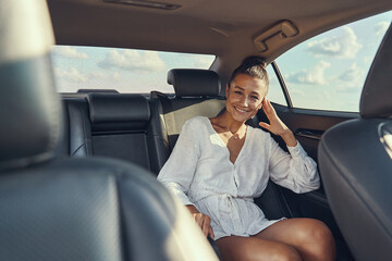 Woman sitting on rear seat of automobile