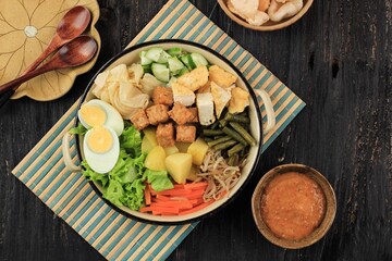 Gado Gado Indonesian Mix Salad from Boiled or Steam Vegetable Served with Peanut Sauce. Gado-Gado Siram Popular in Jakarta Made from Potato, Tempeh, Tofu, Sprout, Carrot, Long Bean, and Egg