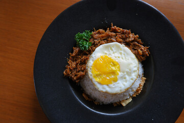 Menu of bluron duck on the wooden table. bluron duck is slow-cooked pulled duck, marinated herbs, steamed rice, sunny side-up eggs. top view