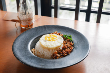 Menu of bluron duck on the wooden table. bluron duck is slow-cooked pulled duck, marinated herbs, steamed rice, sunny side-up eggs