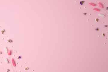 Cosmetic background with flowers on pink. Flat lay, copy space