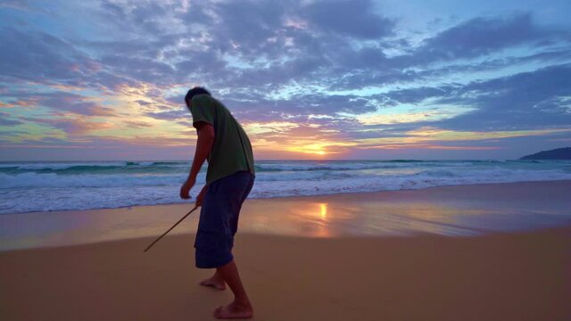 Travel tourism man writing text 2022 on sand at sunset or sunrise with beautiful light of nature on sandy shore Beautiful Beach Dramatic sky sunset in Phuket Thailand