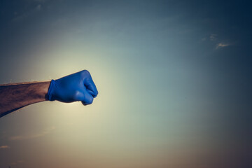 Male hands in medical blue gloves. COVID-19. Coronavirus. Cloudy sky background.