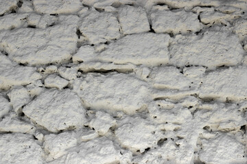 Fragment of the wall from natural stone painted with lime