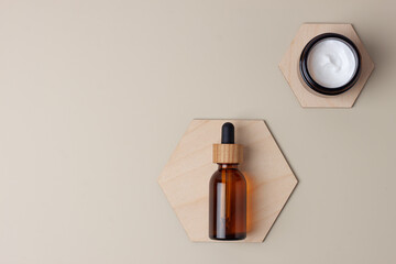 Cosmetic skin care products with a wooden hexagon on pastel beige background. Flat lay, copy space