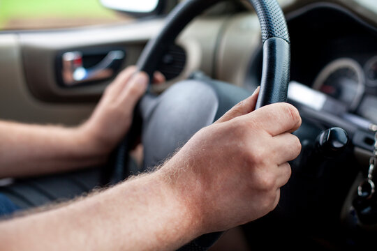 Cropped hands of man holding steering wheel