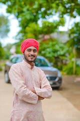 Fototapeta premium Young indian farmer standing his farmhouse.