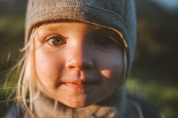 Child girl face portrait close up looking at camera cute baby 2 years old smiling wearing hat...