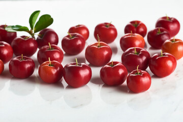 Grupo de acerolas em fundo de mármore branco
