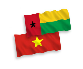 National vector fabric wave flags of Republic of Guinea Bissau and Vietnam isolated on white background. 1 to 2 proportion.