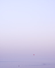 Minimalist view of a parasailer and a boat on the Becici sea, Montenegro, with colorful purple sky and a lot of copy space