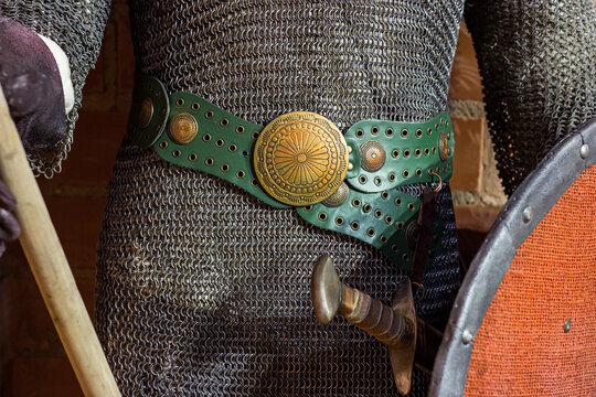 Old historical medieval iron knight armor for ancient warriors protection in combat with belt buckle decoration. Traditional past fighter heavy metal defense equipment in battle or tournament.