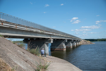 Fisherman near the bridge over the Vileika reservoir