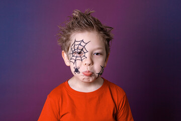 Cute little boy with Halloween makeup in gloomy emotions.