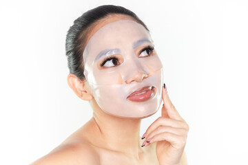 A beautiful Asian woman wearing a collagen face mask. Skincare concept, anti-aging moisturizing mask, hydrogel face mask, cosmetology.