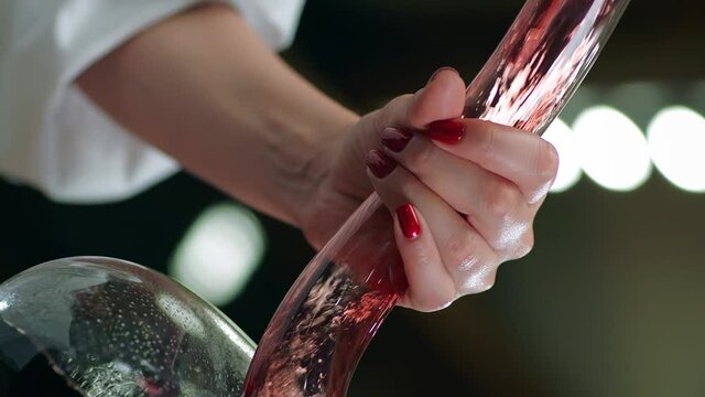 Sommelier pouring red wine from bottle into decanter . Close-up footage of wine mixing process in carafe . Preparation process to degustation of wine. Shot on RED HELIUM Cinema Camera in Slow Motion.
