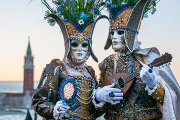 Male and female wearing masks, hats and carnival costumes in Venice, Italy