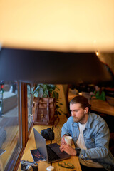 Concentrated on work caucasian male designer working on marketing project at cafe, skilled handsome...