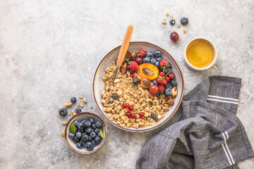 Oat granola with fruits in bowl on concrete background. berry and blueberries with crunchy oat honey granola, healthy breakfast cereals