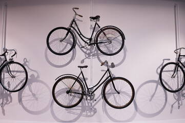 Naklejka premium Old bicycles hang on a white wall as decorations