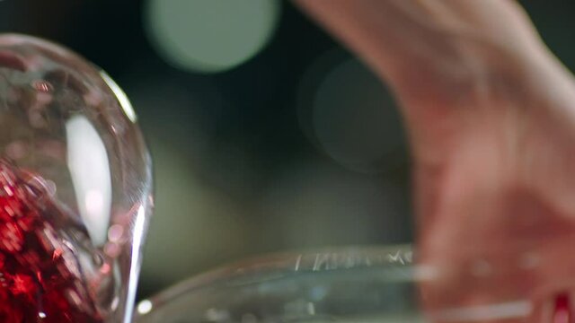 Sommelier pouring red wine from bottle into decanter . Close-up footage of wine mixing process in carafe . Preparation process to degustation of wine. Shot on RED HELIUM Cinema Camera in Slow Motion.