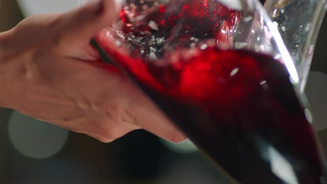 Sommelier pouring red wine from bottle into decanter . Close-up footage of wine mixing process in carafe . Preparation process to degustation of wine. Shot on RED HELIUM Cinema Camera in Slow Motion.