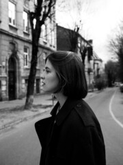 young thoughtful female, city center location, monochrome photograph, street style
