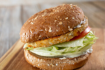 A view of a burger, featuring a burger patty made of plant-based ingredients.