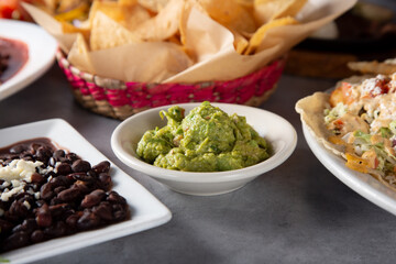A view of a side of guacamole, among other Mexican and Tex-Mex entrees.