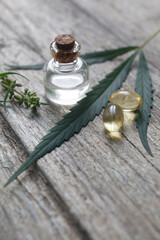 cannabis (hemp) essential oil bottle with cannabis leaves and seeds on wooden background
