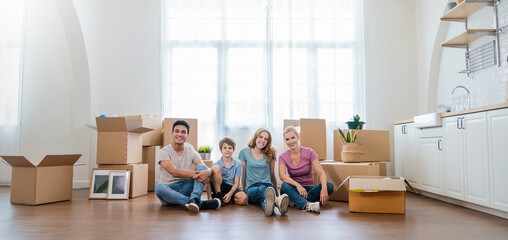 Caucasian family father mother child packing cardboard box move to new house, apartment. Portrait of couple unpack stuff belonging home delivery. Lifestyle happy white family together relocate concept